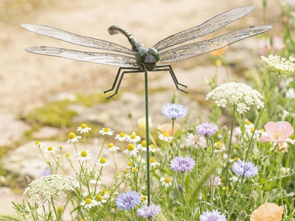 Large realistic dragonfly garden stake among white wildflowers