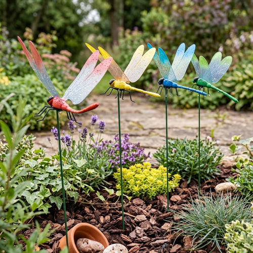 Assorted dragonfly plant stakes arranged along a garden path