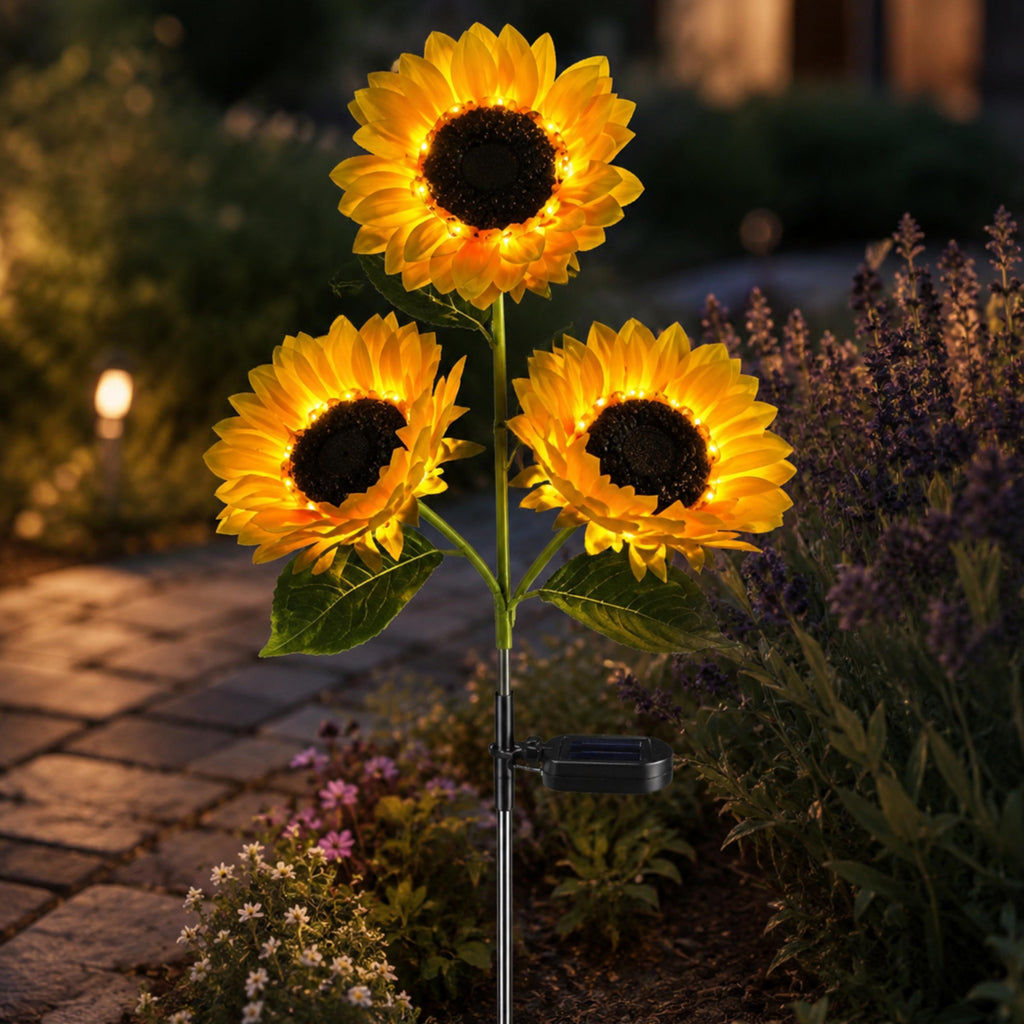 Close view of one solar stake with three glowing sunflower lights