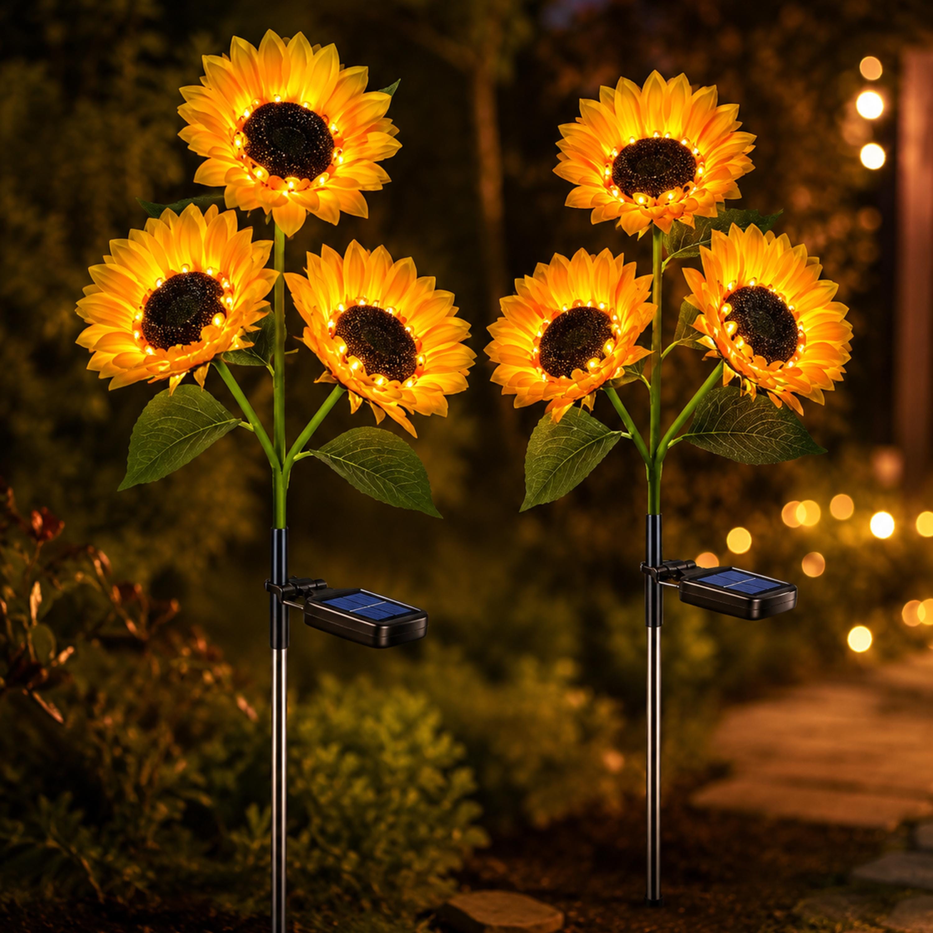 Two solar sunflower garden stakes with three glowing flowers each