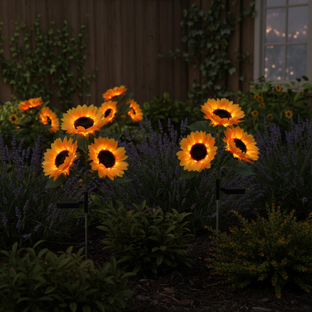 Glowing solar sunflower stake lights among dark garden flowers