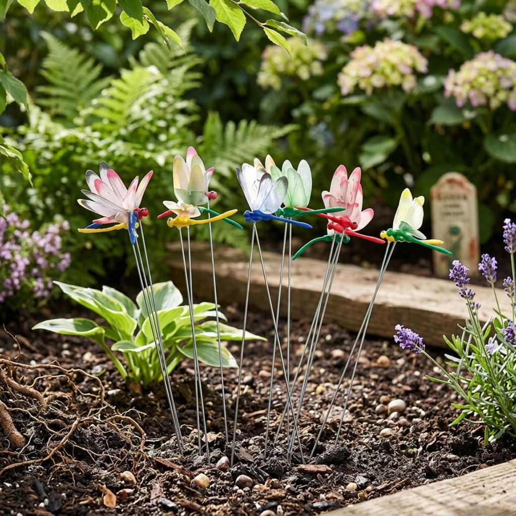 Set of dragonfly garden stakes arranged in a mulched flower bed
