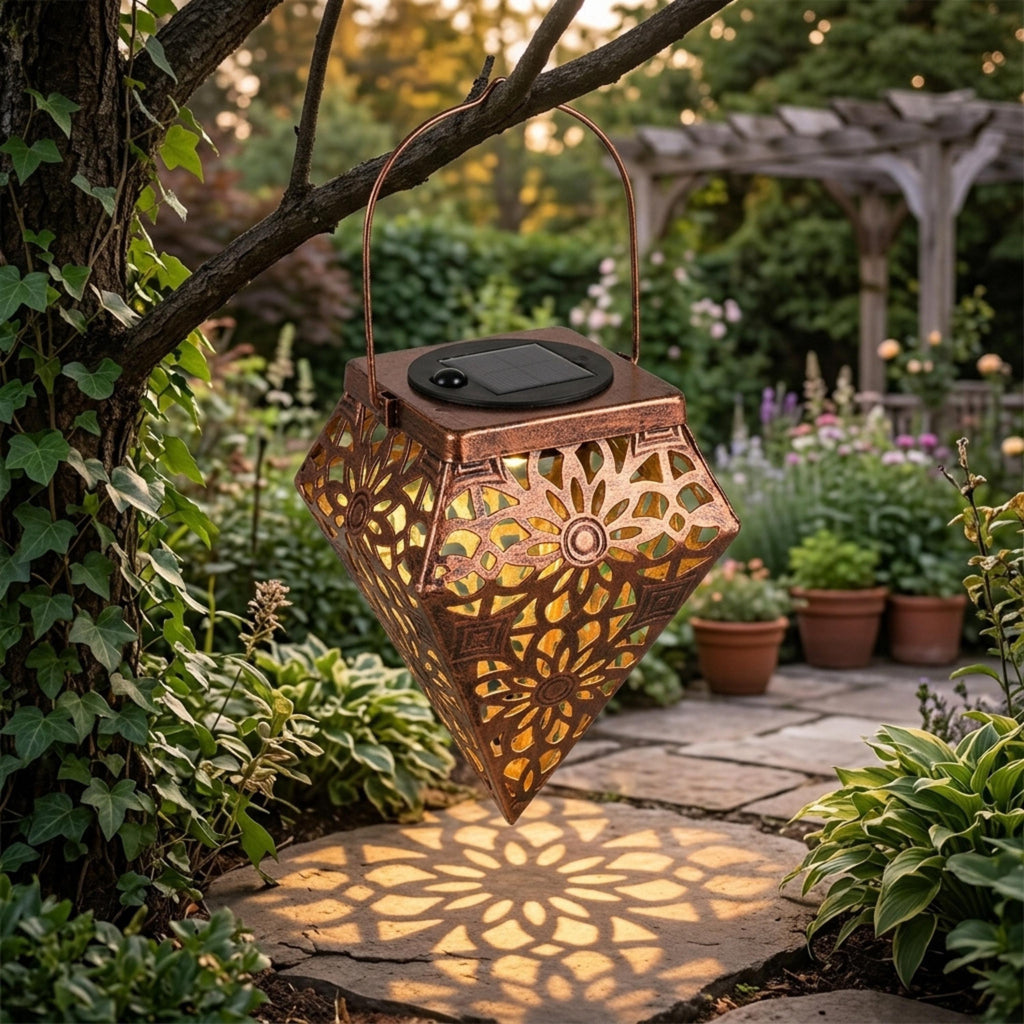 Floral cutout solar lantern casting warm patterns beneath a tree branch