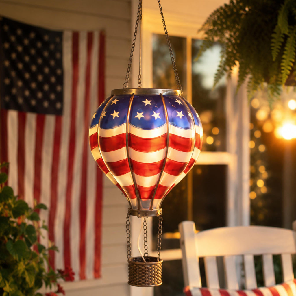 Stars-and-stripes solar balloon lantern hanging beside an American flag
