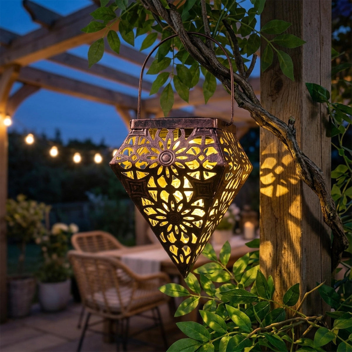 Antique bronze solar lantern hanging from a pergola and casting flower shadows