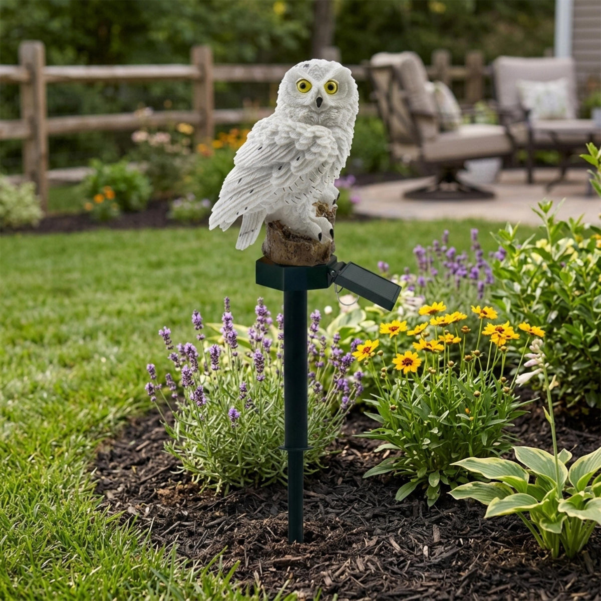 White solar owl garden stake among lavender and yellow flowers