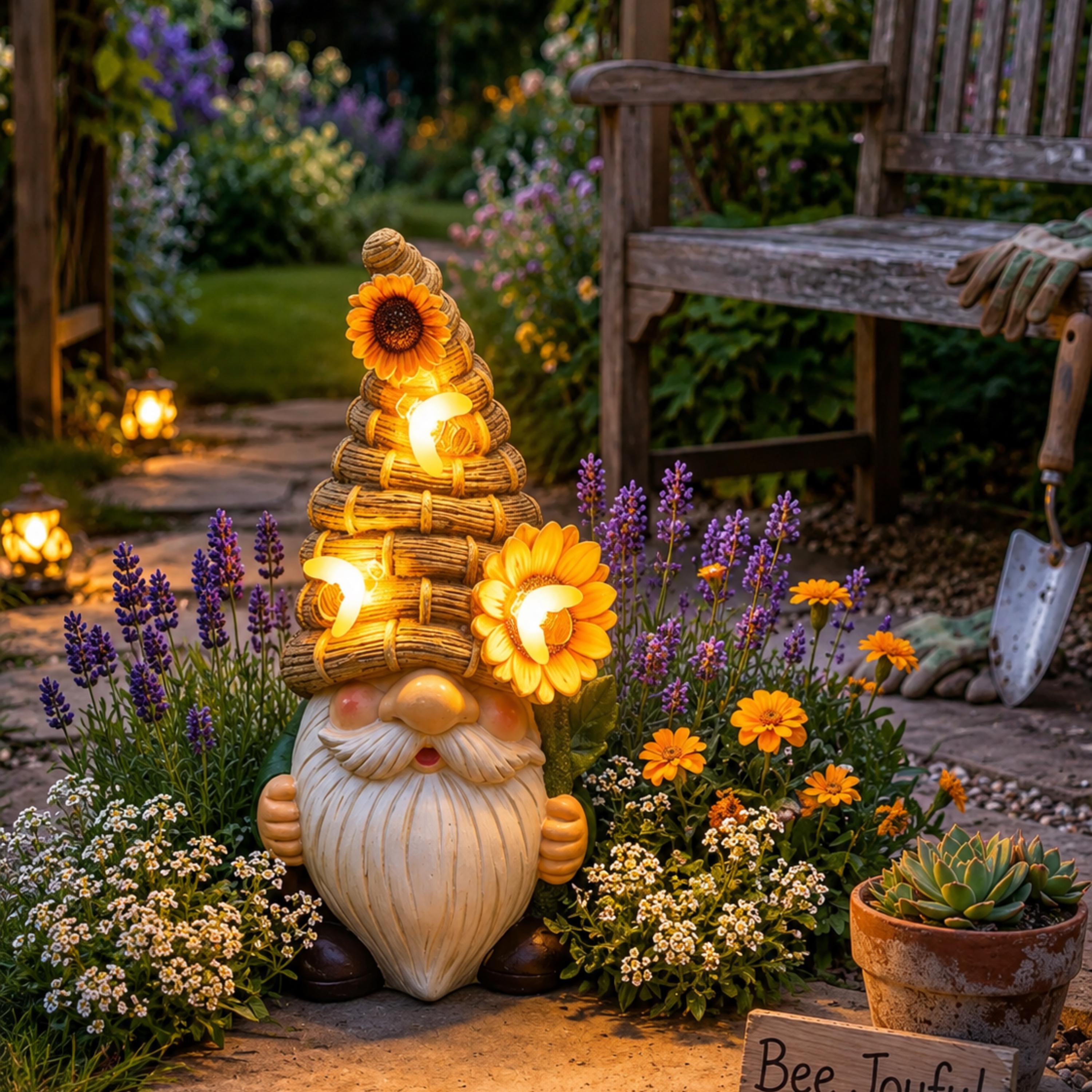 Stacked beehive solar gnome glowing beside a Bee Joyful garden sign