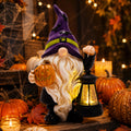 Solar Halloween gnome holding a pumpkin and glowing lantern