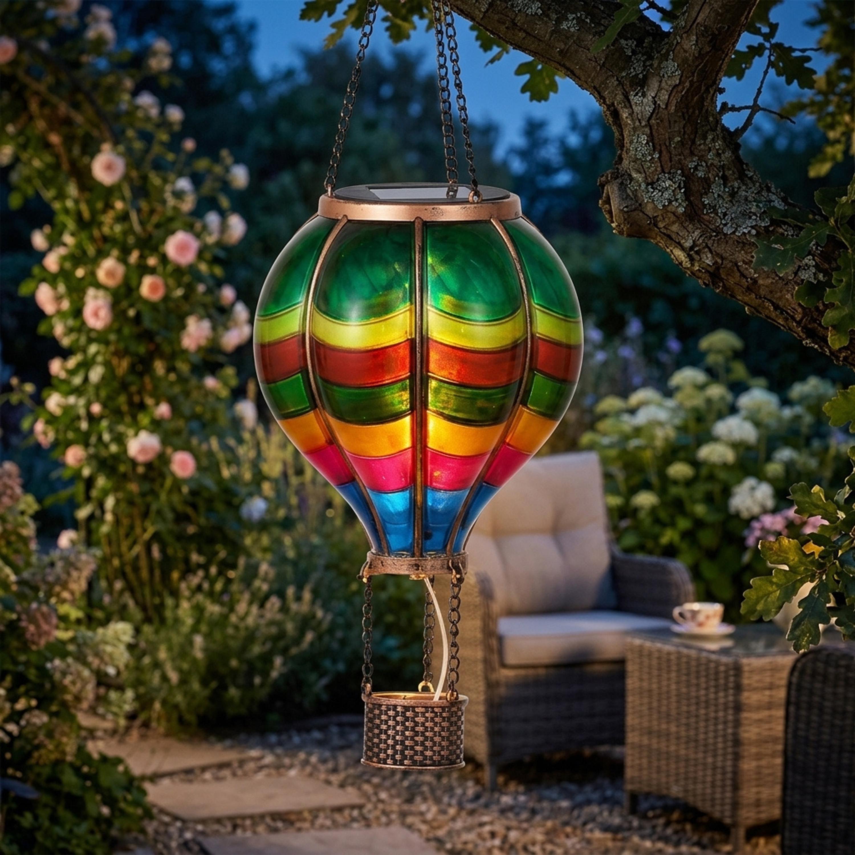 Multicolor hot air balloon solar lantern glowing beneath a tree