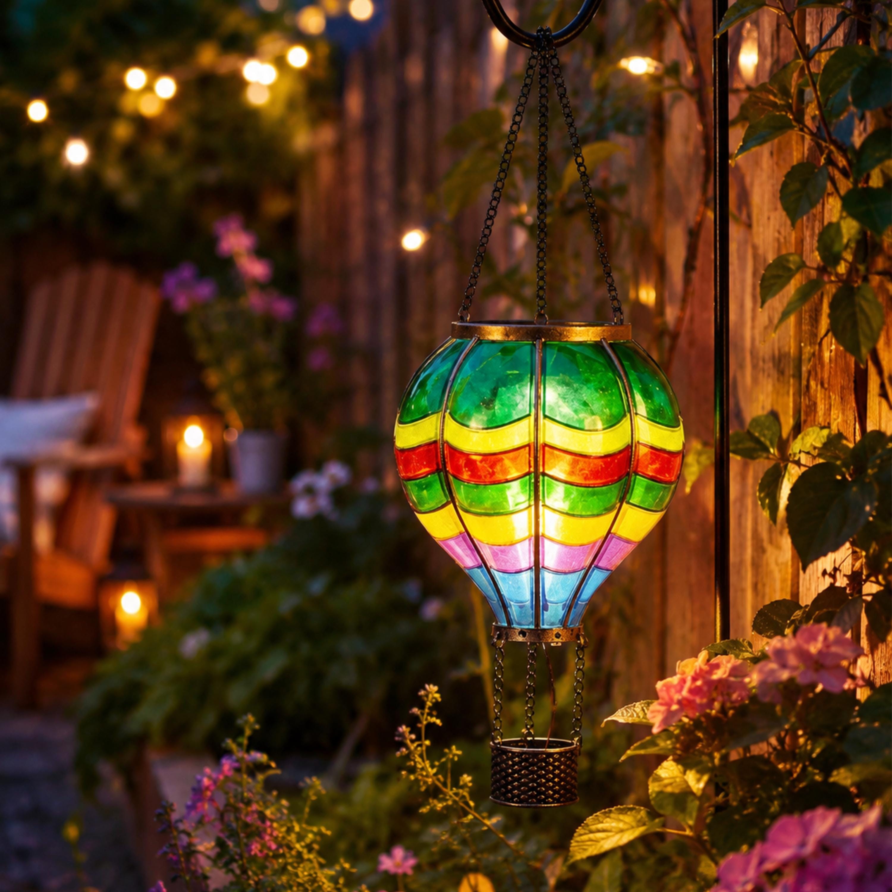 Colorful solar balloon lantern glowing beside a wooden fence and flowers
