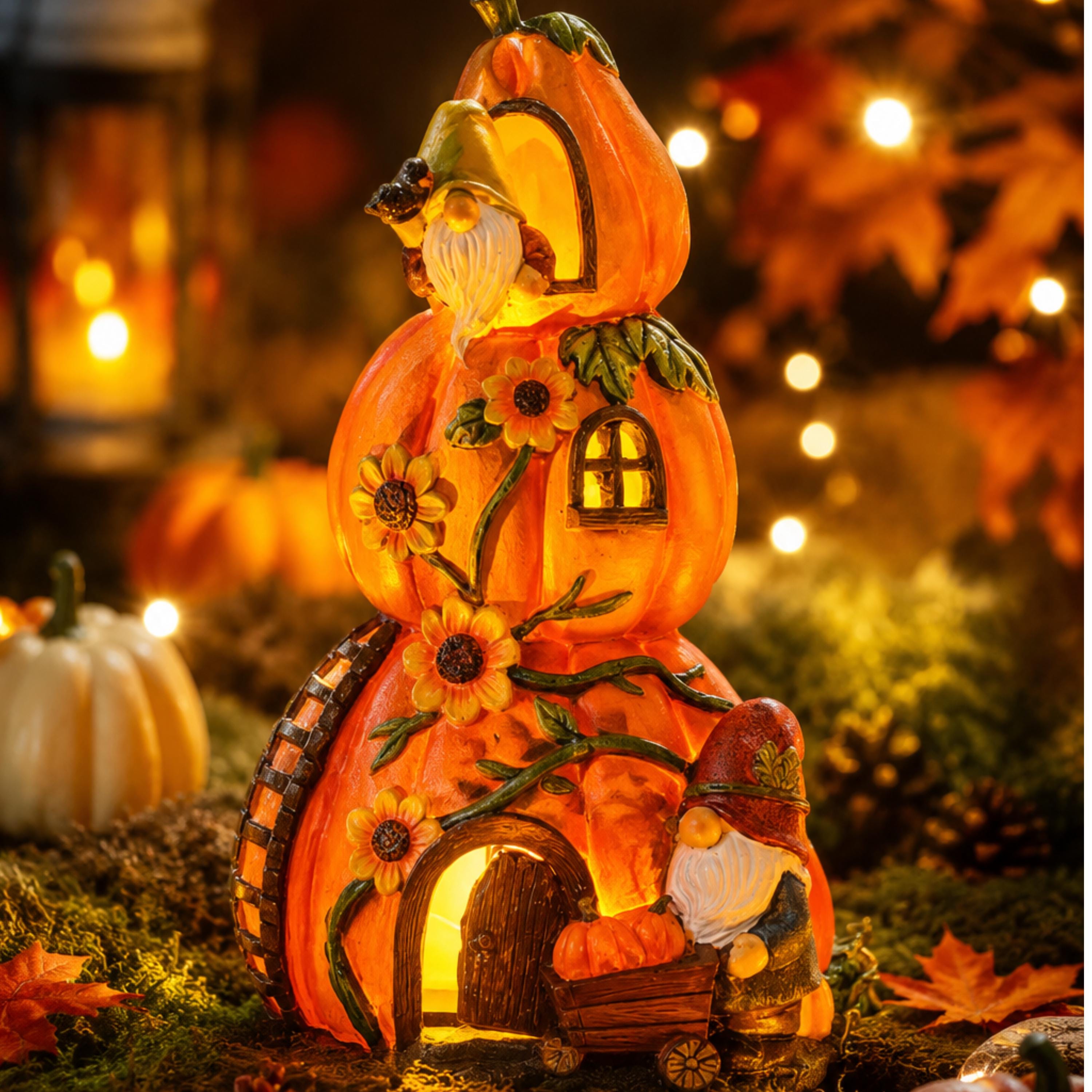 Solar pumpkin cottage statue glowing among autumn leaves and pumpkins