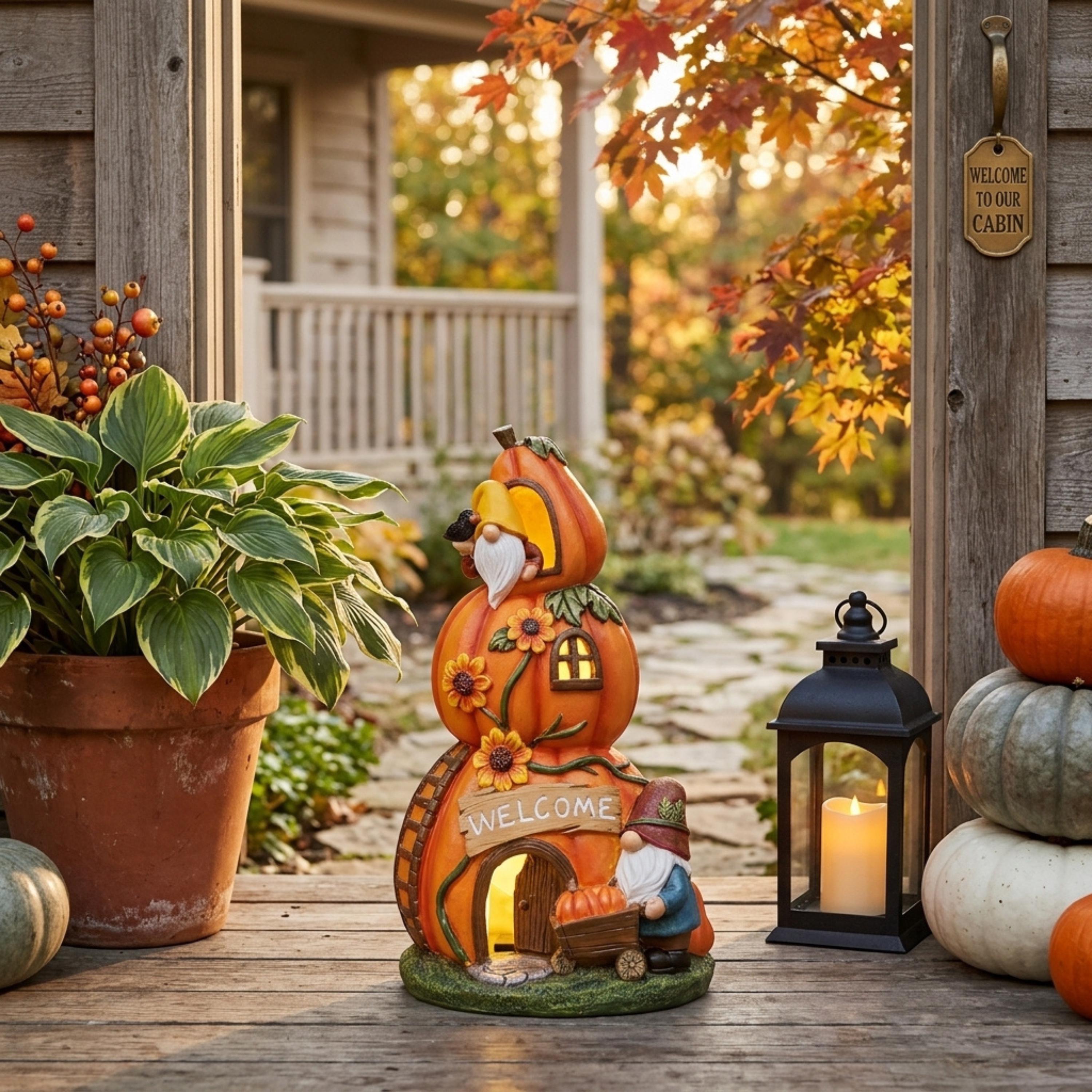 Solar pumpkin house with gnomes displayed on a covered fall porch